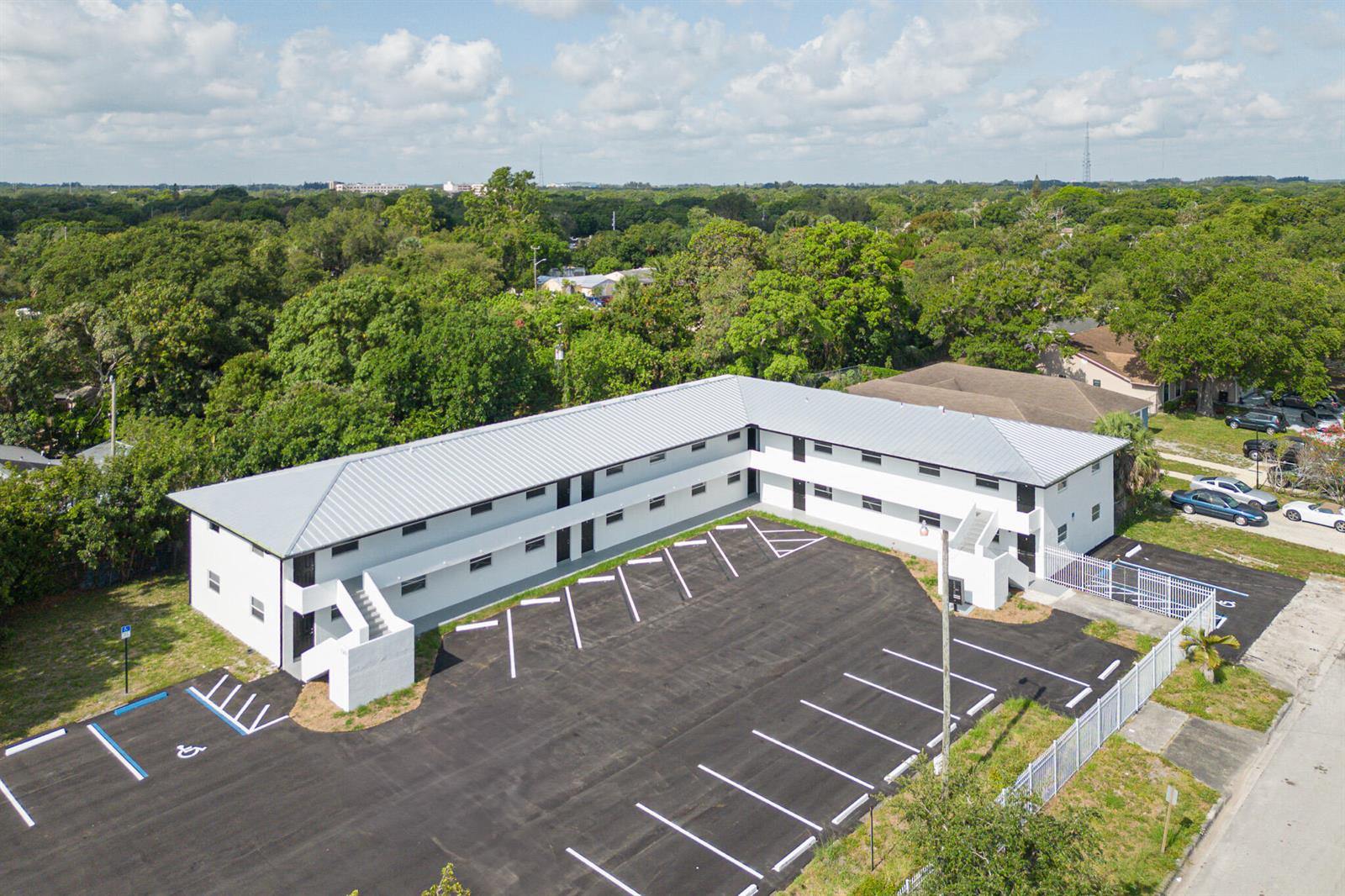 An aerial view shows a two-story white apartment building with a metal roof and parking lot — 1301 Emerald Terrace # 4, Fort Pierce FL 34950, FORT PIERCE, FL