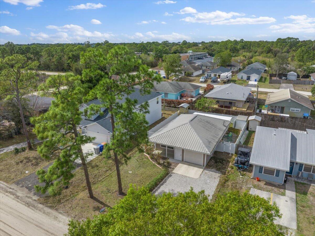 An aerial view shows a residential neighborhood with several houses, pine trees, and gravel driveways — 2135 87th Avenue, Vero Beach FL 32966, VERO BEACH, FL