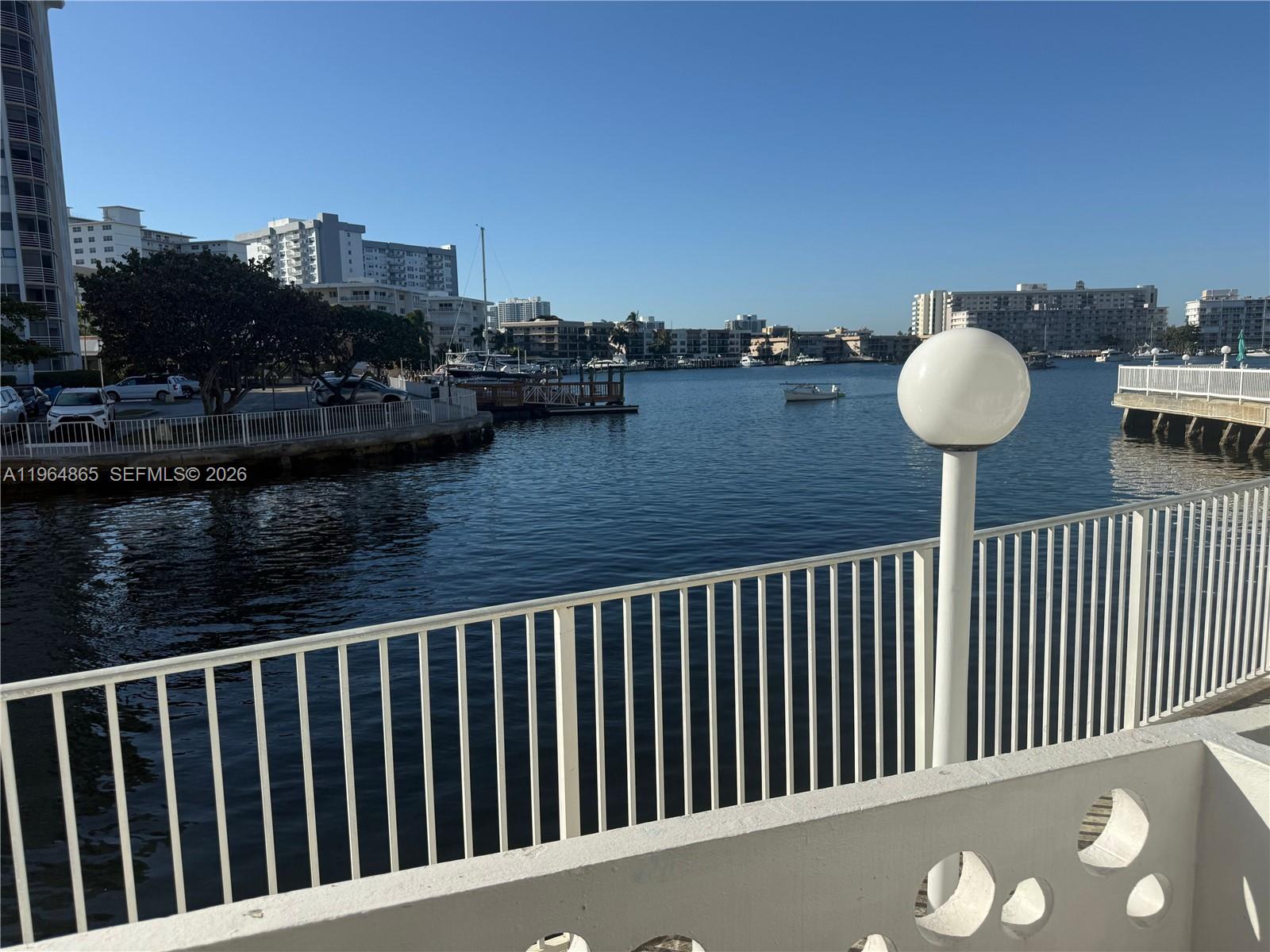 A view of a waterfront marina from a balcony with a white railing — 2500 Diana Dr # 107, Hallandale Beach FL 33009, HALLANDALE BEACH, FL