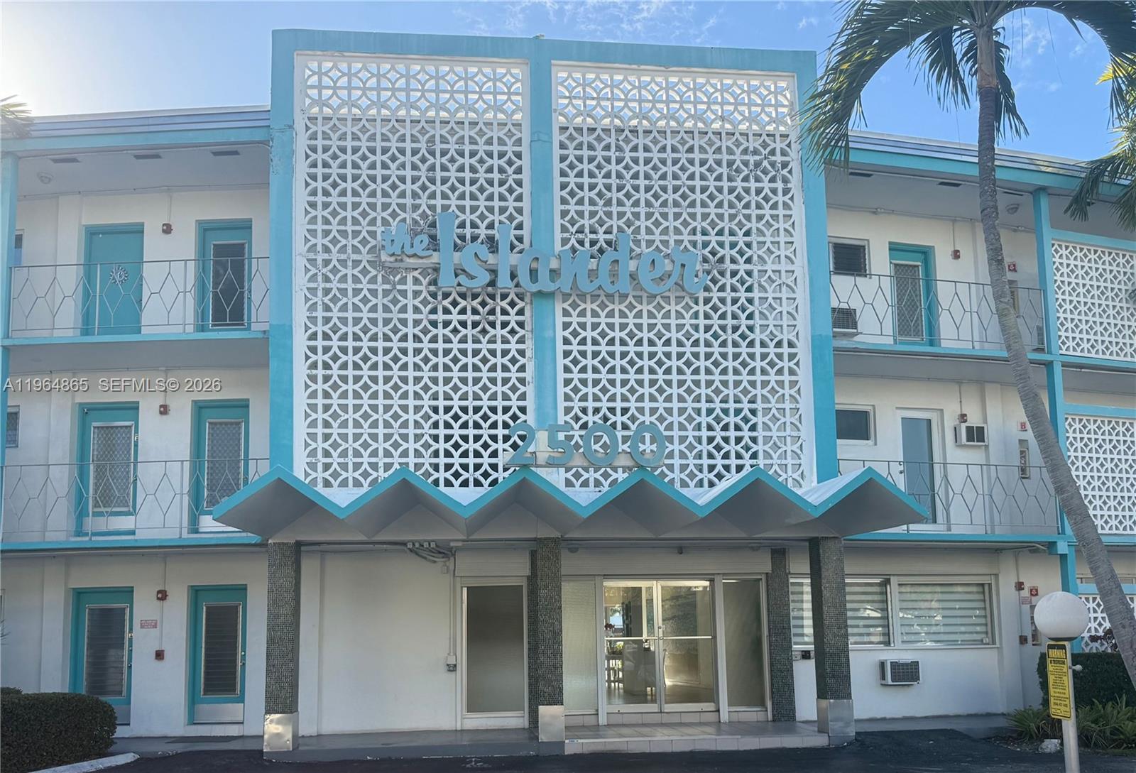The exterior of a mid-century modern apartment building features a decorative screen and zigzag awning — 2500 Diana Dr # 107, Hallandale Beach FL 33009, HALLANDALE BEACH, FL