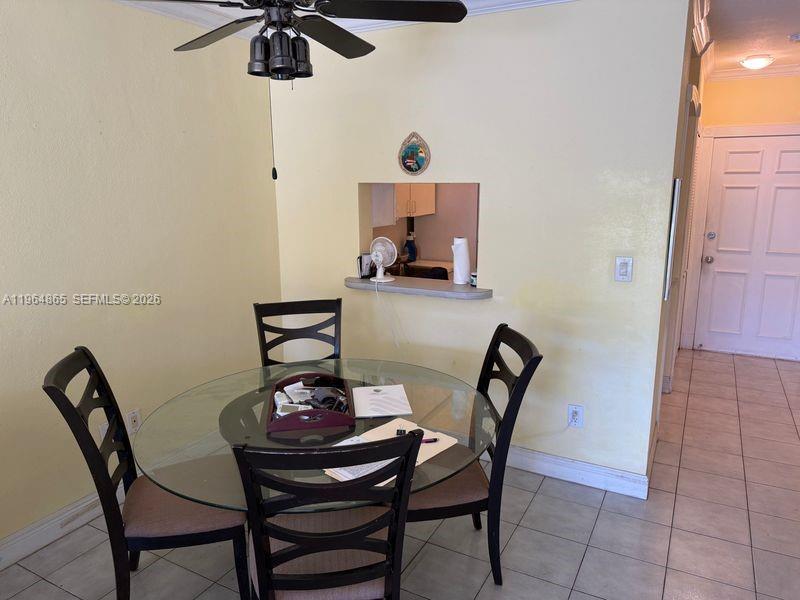 A dining area features a glass-topped table, four chairs, and a pass-through window — 2500 Diana Dr # 107, Hallandale Beach FL 33009, HALLANDALE BEACH, FL