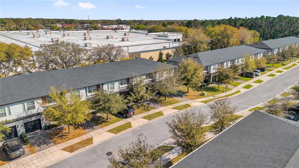 An aerial view shows a row of townhouses with gray roofs and paved driveways — 4431 LE REVE COURT, KISSIMMEE, FL