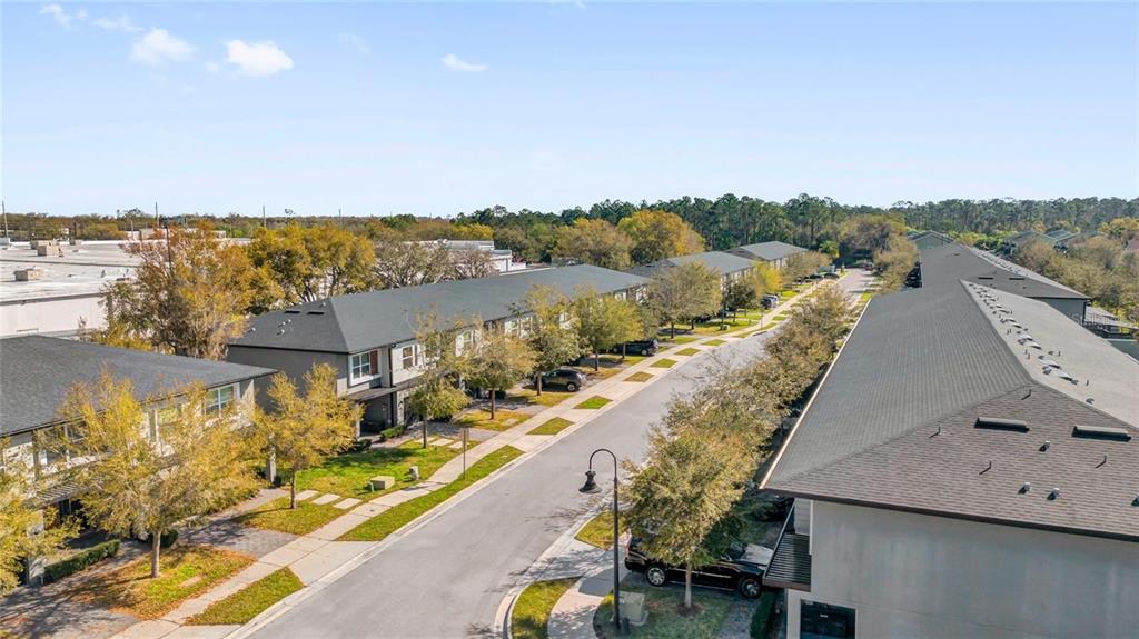 An aerial view shows multiple multi-story townhome buildings along a paved residential street — 4431 LE REVE COURT, KISSIMMEE, FL