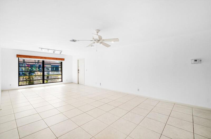 An empty room with white walls, tiled flooring, a ceiling fan, and a large window — 10120 Eaglewood Terrace # B, Boynton Beach FL 33436, BOYNTON BEACH, FL