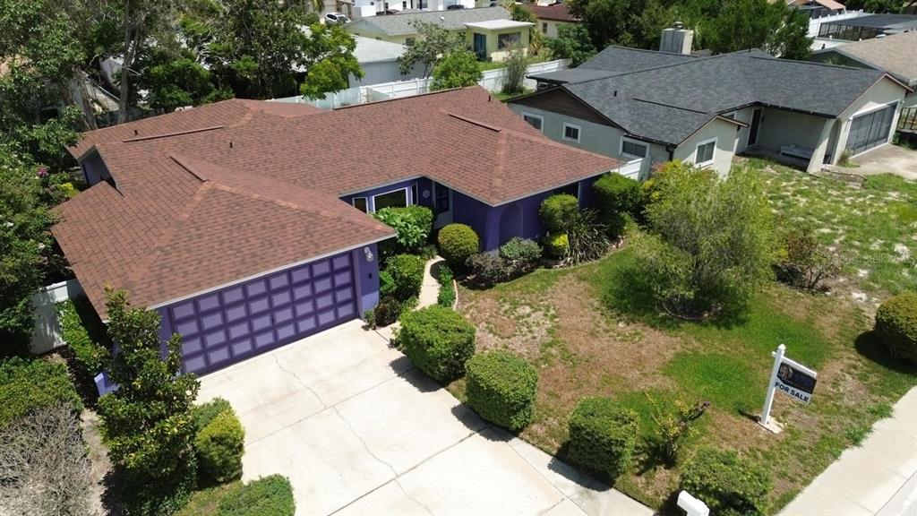 An aerial view shows a purple house with a brown roof and a concrete driveway — 9836 MOREHEAD LANE, PORT RICHEY, FL