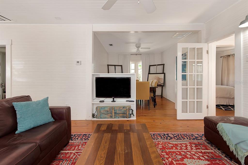A living room with a leather sofa, a television on a partition, and hardwood floors — 4416 123RD ST COURT W, CORTEZ, FL