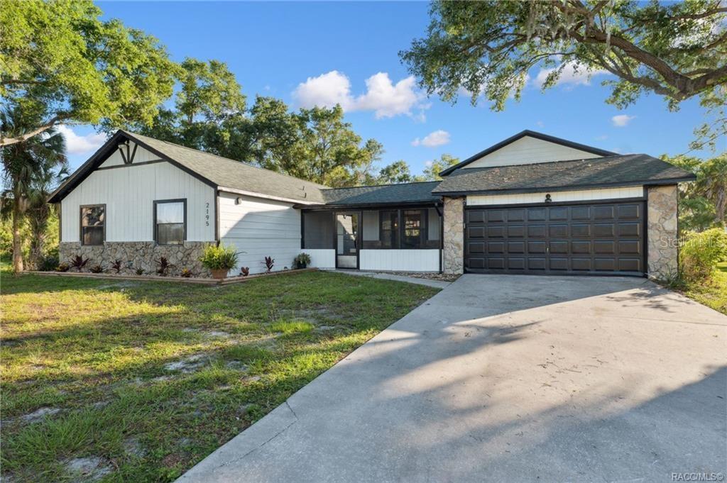 A single-story house with a stone facade, white siding, and an attached two-car garage — 2195 N SLEWFOOT PATH, CRYSTAL RIVER, FL