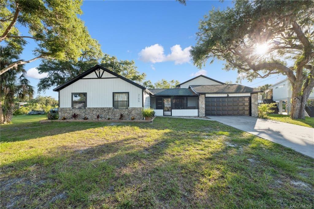 A single-story house with a stone facade, white siding, and an attached two-car garage — 2195 N SLEWFOOT PATH, CRYSTAL RIVER, FL