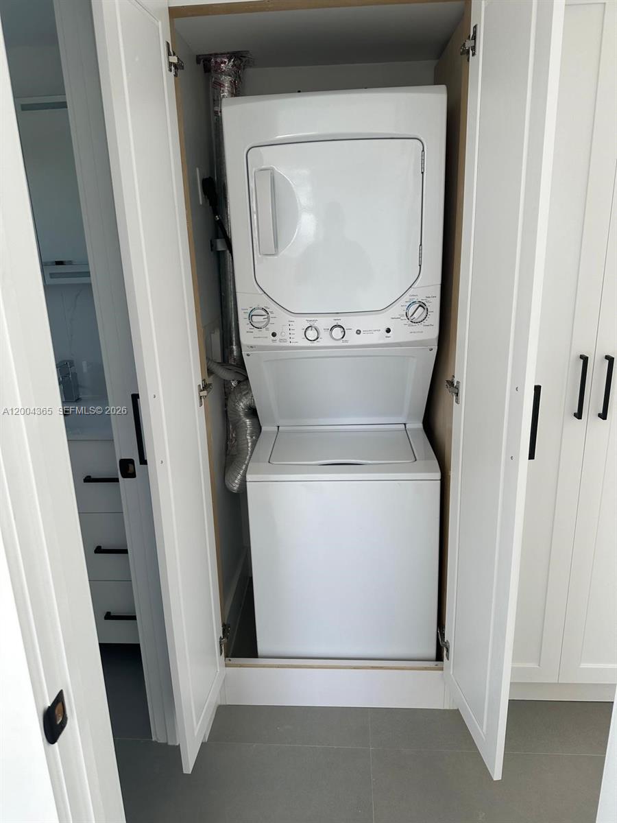 A stacked washer and dryer unit is installed inside a white closet — 360 Meridian Ave # 3E, Miami Beach FL 33139, MIAMI BEACH, FL