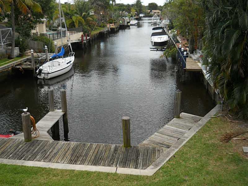 A wooden dock overlooks a narrow canal with several boats moored along the banks — 520 SW 15th Street # 101, Pompano Beach FL 33060, POMPANO BEACH, FL
