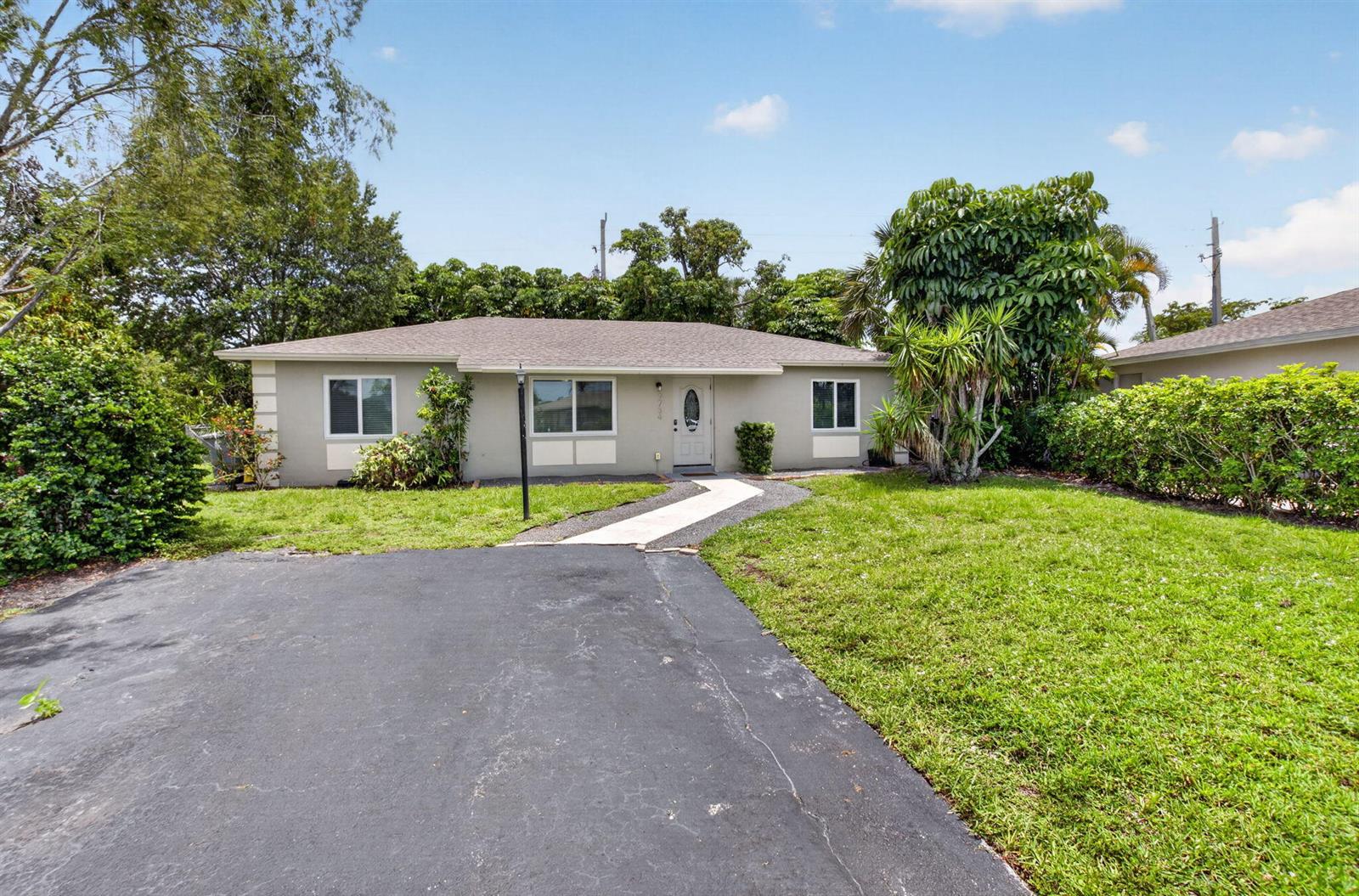 A single-story house with a gray exterior, asphalt driveway, and a front walkway — 9734 Alaska Circle, Boca Raton FL 33434, BOCA RATON, FL