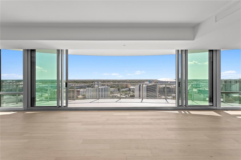 An empty room with light wood floors and large sliding glass doors opening to a balcony — 400 CENTRAL AVENUE UNIT 1801, ST PETERSBURG, FL
