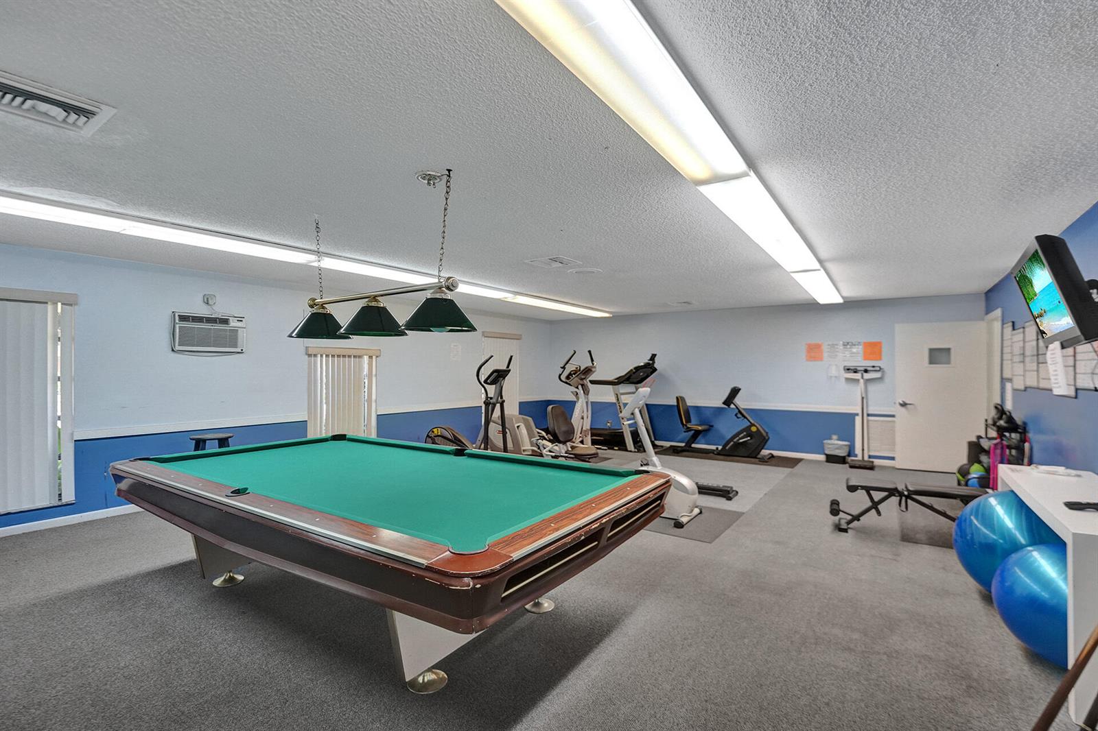 A recreation room features a pool table, various exercise equipment, and blue-painted lower walls — 201 NW 76th Avenue # 203, Margate FL 33063, MARGATE, FL