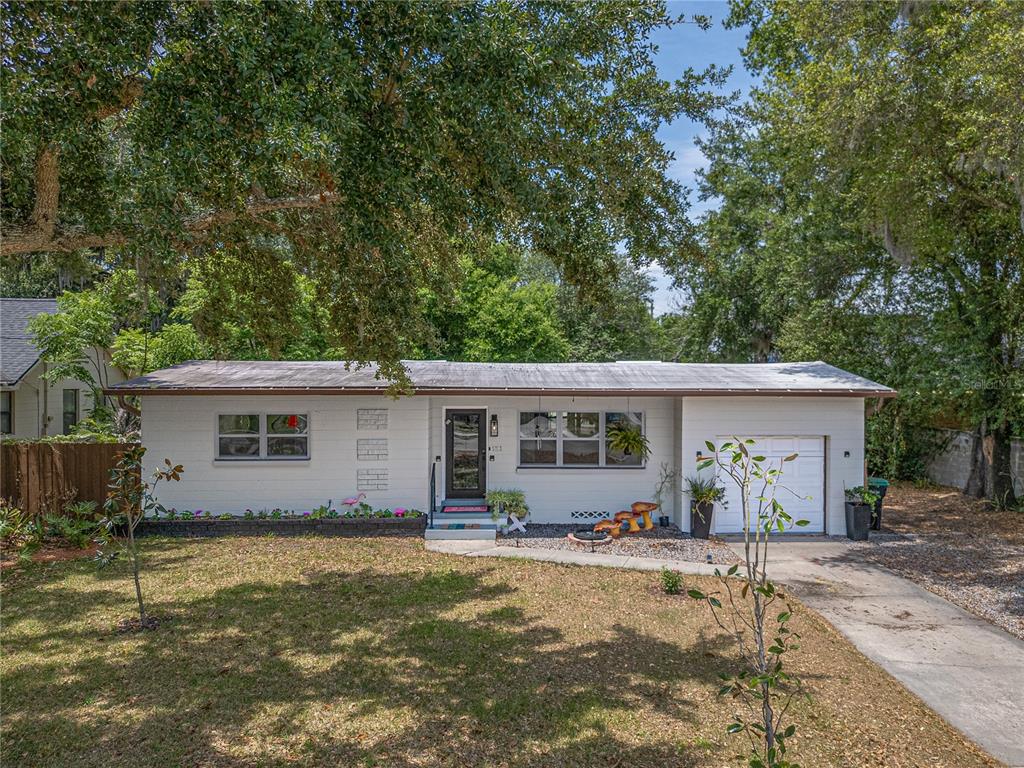 A single-story white brick house with a garage, a front yard, and mature trees — 2702 S SHINE AVENUE, ORLANDO, FL