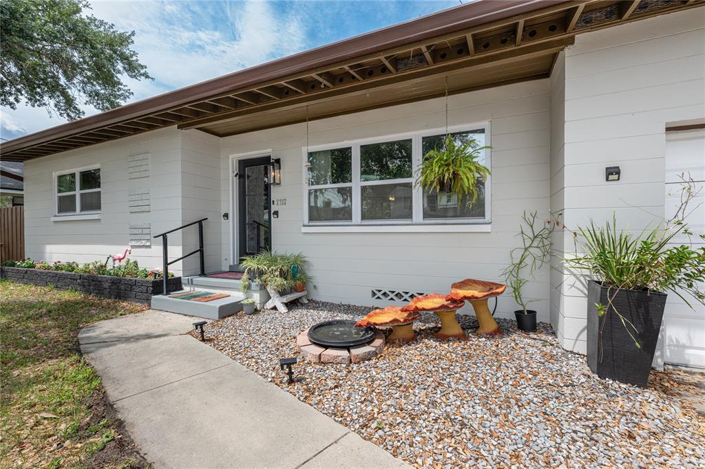 A single-story house exterior features white siding, a gravel front yard, and a concrete walkway — 2702 S SHINE AVENUE, ORLANDO, FL