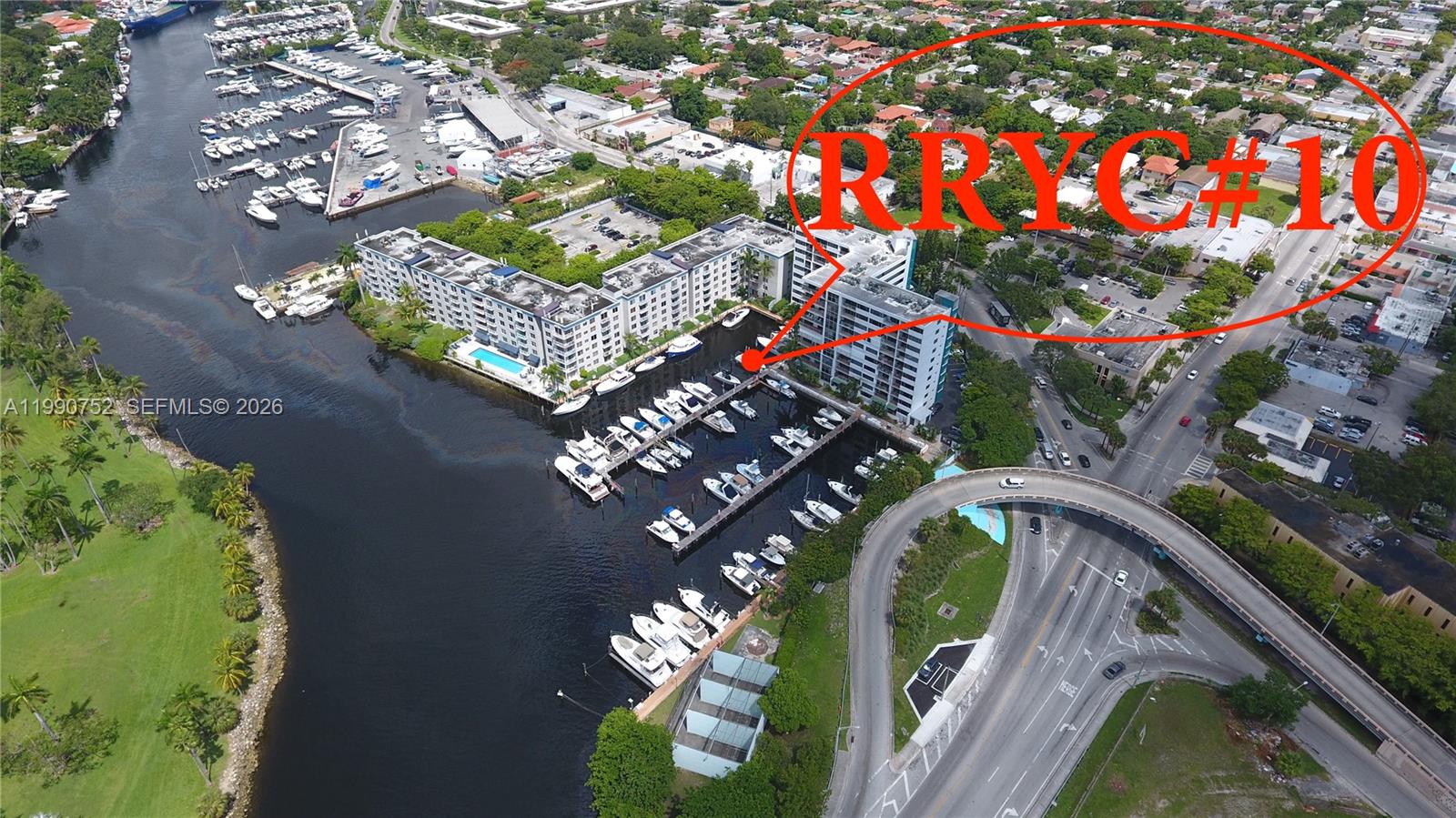 An aerial view shows a waterfront condominium complex with a private marina and boat slips — 1700 NW North River Dr, Miami FL 33125, MIAMI, FL