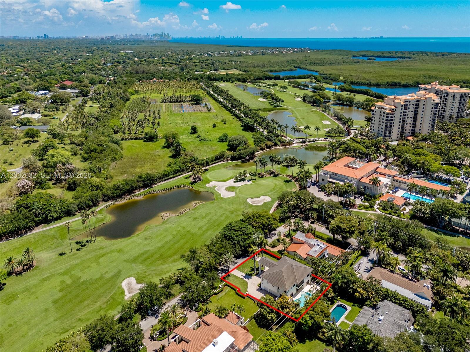 An aerial view shows a house with a pool situated next to a golf course — 6220 SW 144th St, Coral Gables FL 33158, CORAL GABLES, FL