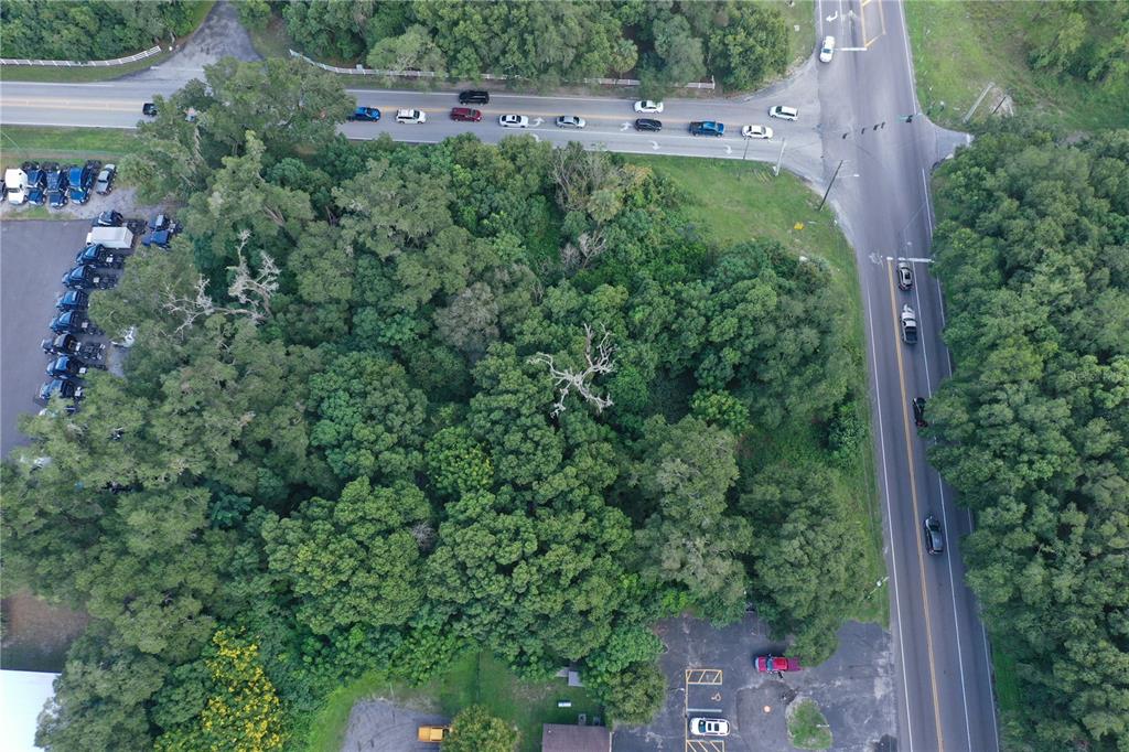An aerial view shows a wooded lot situated at the intersection of two paved roads — 24439 SORRENTO AVENUE, SORRENTO, FL