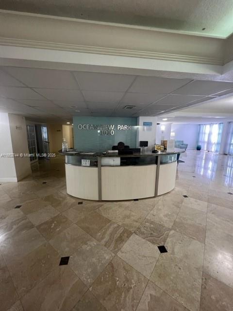 A lobby features a curved reception desk in front of a sign reading Oceanview Park 1000 — 1000 Parkview Dr # 523, Hallandale Beach FL 33009, HALLANDALE BEACH, FL