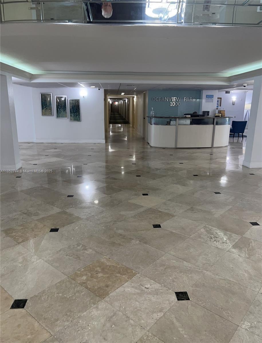 The lobby features a reception desk, marble tile flooring, and a long hallway — 1000 Parkview Dr # 523, Hallandale Beach FL 33009, HALLANDALE BEACH, FL