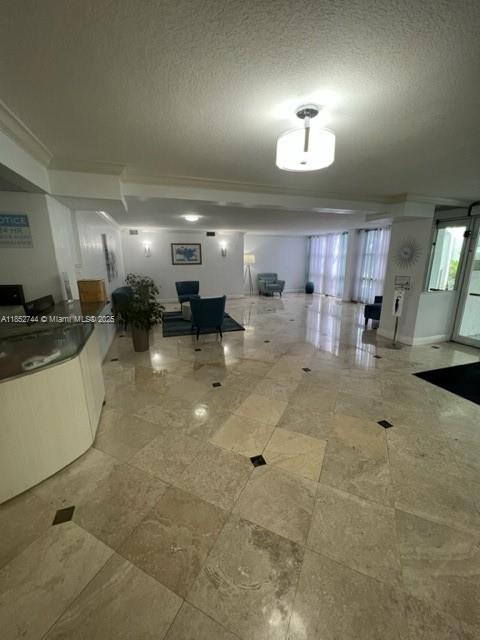 A spacious lobby features light-colored tile flooring, a reception desk, and a seating area — 1000 Parkview Dr # 523, Hallandale Beach FL 33009, HALLANDALE BEACH, FL