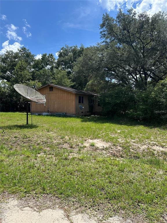 A tan house with a palm tree in the yard and a neighboring white house — 1968 SE 161ST TERRACE, OCKLAWAHA, FL