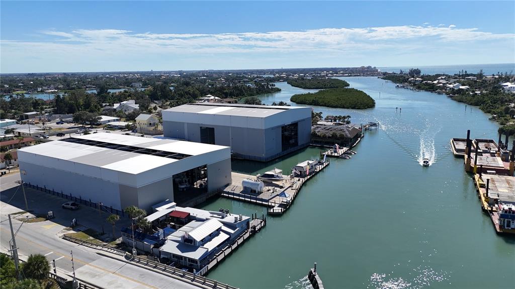 An aerial view shows two large industrial buildings situated along a waterway with boat docks — 100 CIRCUIT ROAD UNIT N-52, NOKOMIS, FL