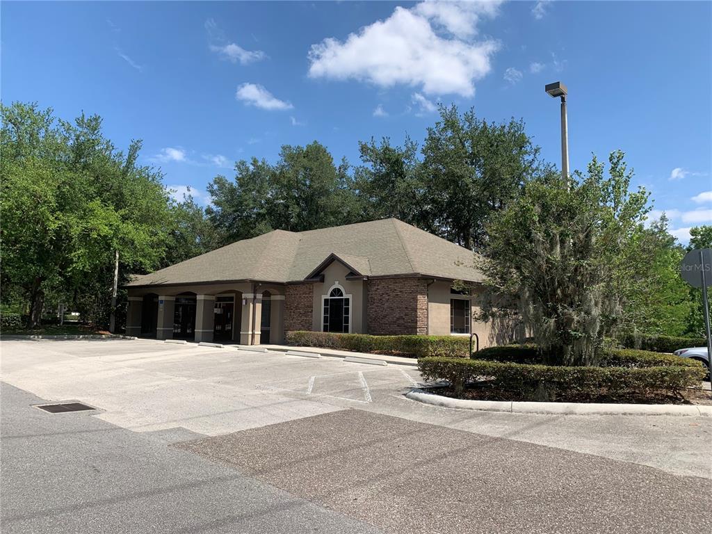 A single-story commercial building with a stone facade and a parking lot in front — 25 WINDSORMERE WAY, OVIEDO, FL