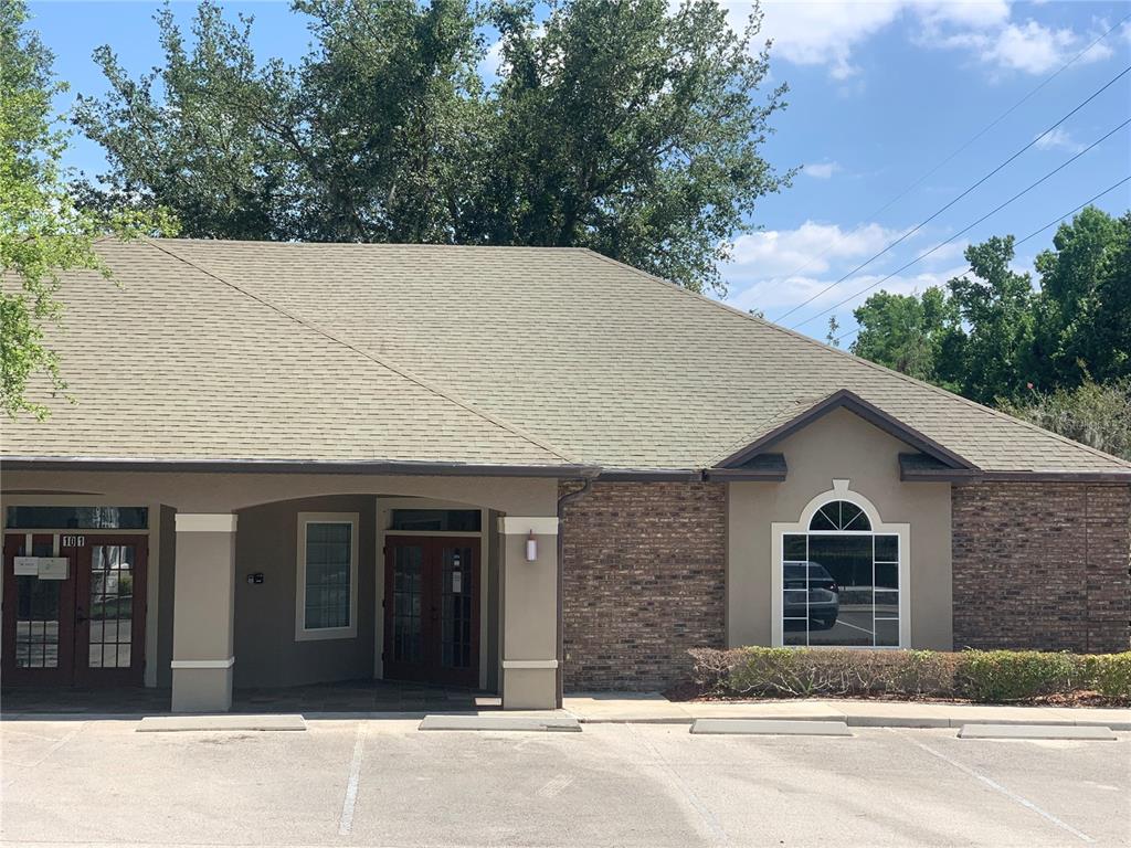 A single-story commercial building features a brick facade, a covered entrance, and a parking lot — 25 WINDSORMERE WAY, OVIEDO, FL