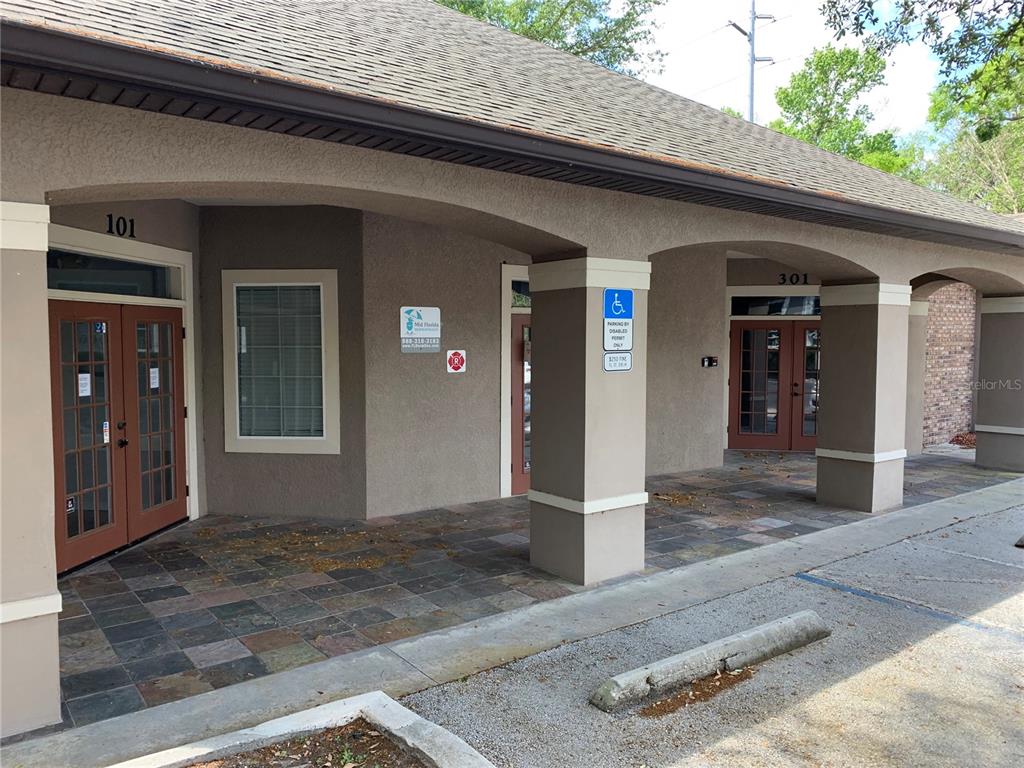 The exterior of a commercial building features two entrance doors labeled 101 and 301 — 25 WINDSORMERE WAY, OVIEDO, FL