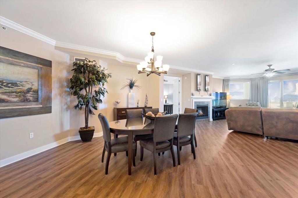 A dining area with a round table and chairs sits adjacent to a living room — 1925 S ATLANTIC AVENUE UNIT 502, DAYTONA BEACH, FL