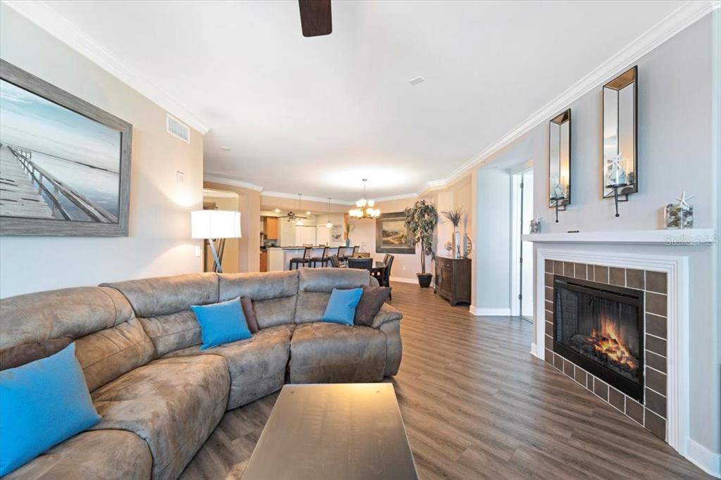 A living room with a brown sectional sofa, fireplace, and open floor plan to dining — 1925 S ATLANTIC AVENUE UNIT 502, DAYTONA BEACH, FL