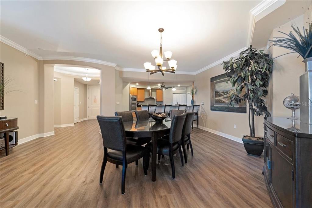 A dining room with wood-look flooring, a dark oval table, and a chandelier — 1925 S ATLANTIC AVENUE UNIT 502, DAYTONA BEACH, FL