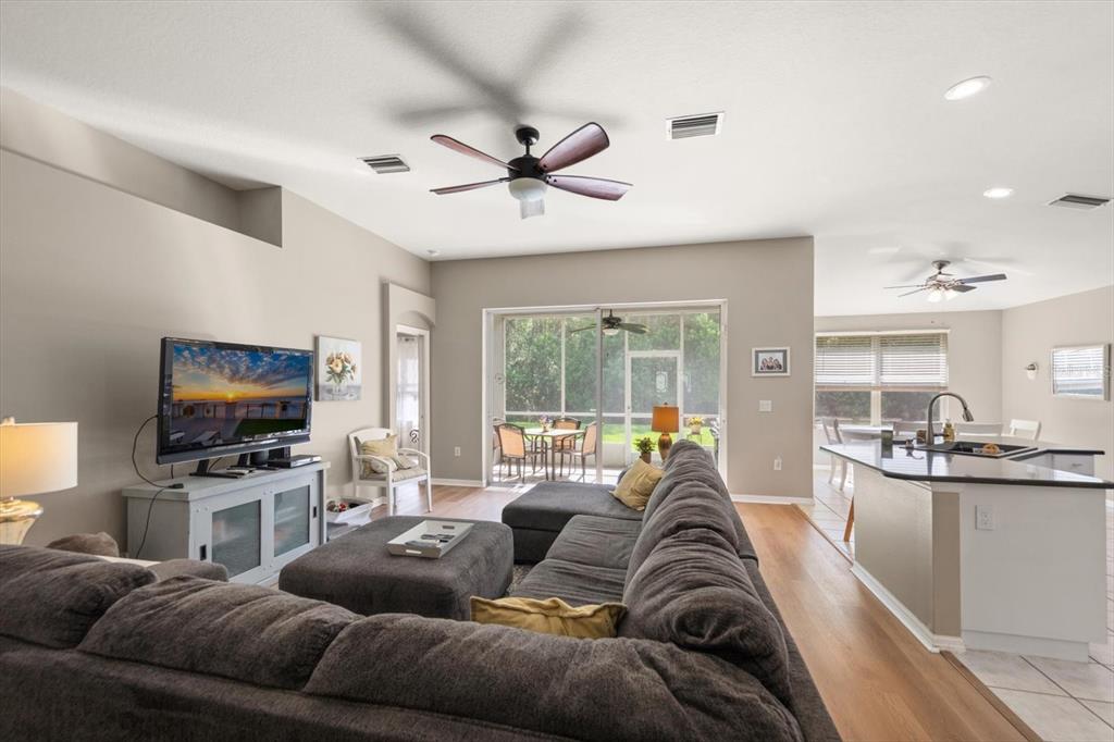 A living room with a sectional sofa, television, and an open kitchen with an island — 4422 HAVELOCKE DRIVE, LAND O LAKES, FL