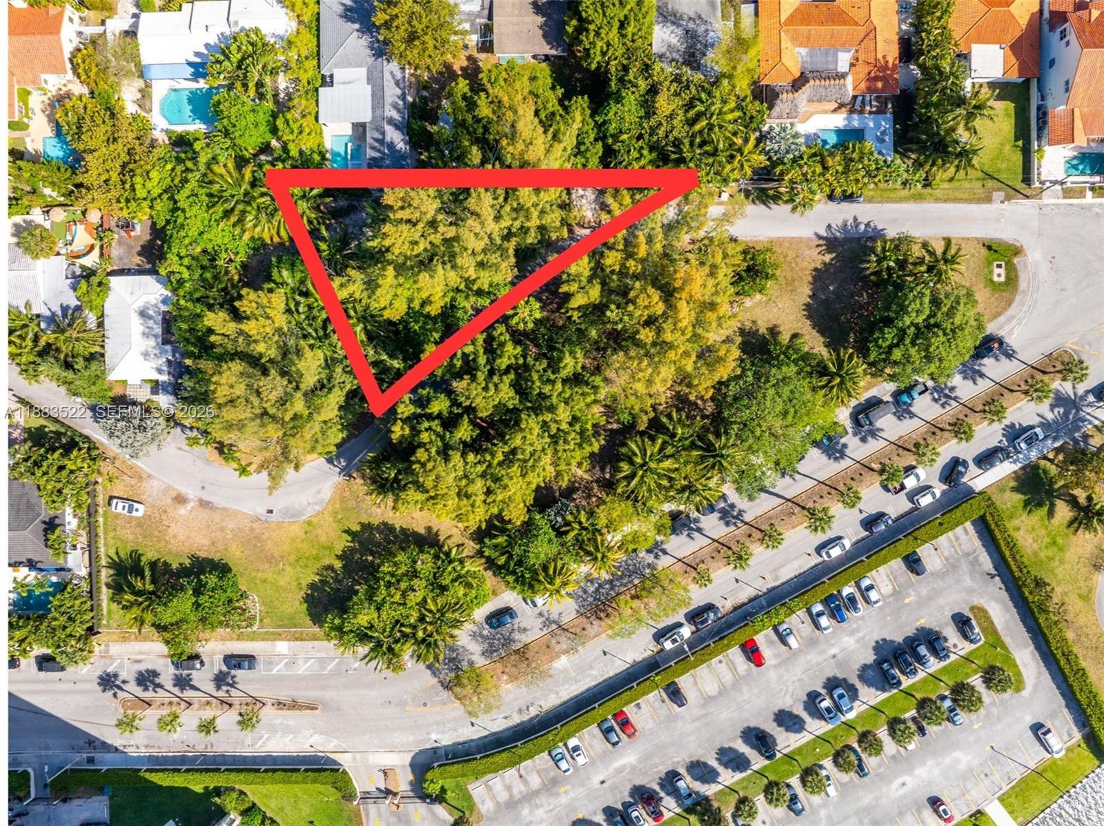 An aerial view shows a triangular wooded lot situated near a parking lot and road — 895 NE 70th St, Miami FL 33138, MIAMI, FL