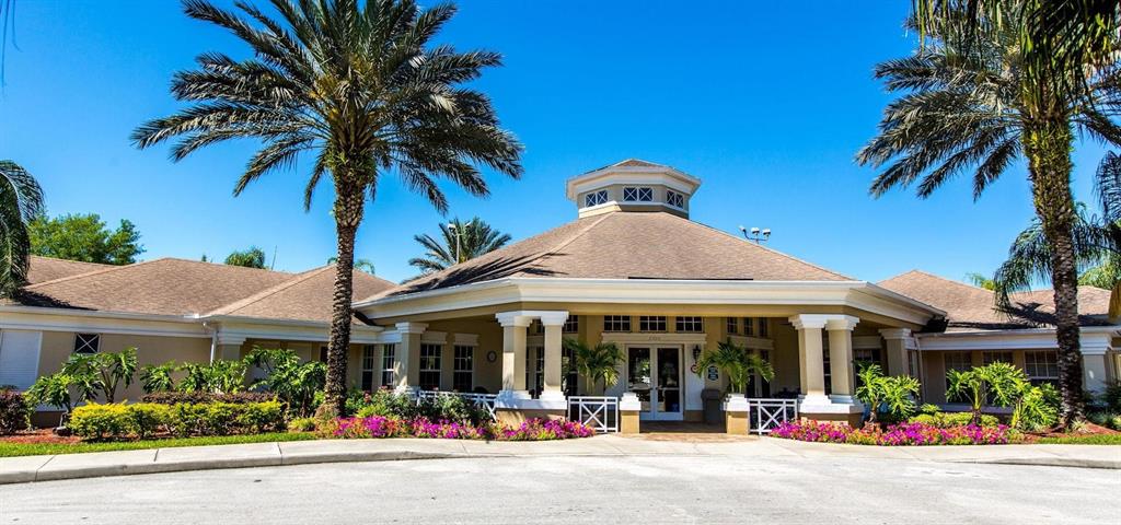 A tan clubhouse building features a central cupola, a covered entrance, and surrounding palm trees — 8100 PRINCESS PALM LANE UNIT 203, KISSIMMEE, FL