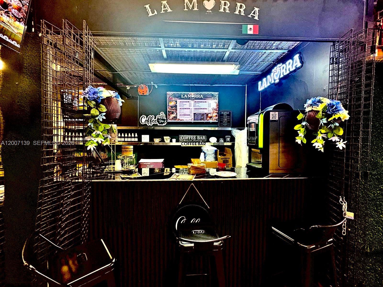 A small coffee bar features a dark wood counter, stools, and a menu board — E Sheridan, Hollywood FL 33021, HOLLYWOOD, FL