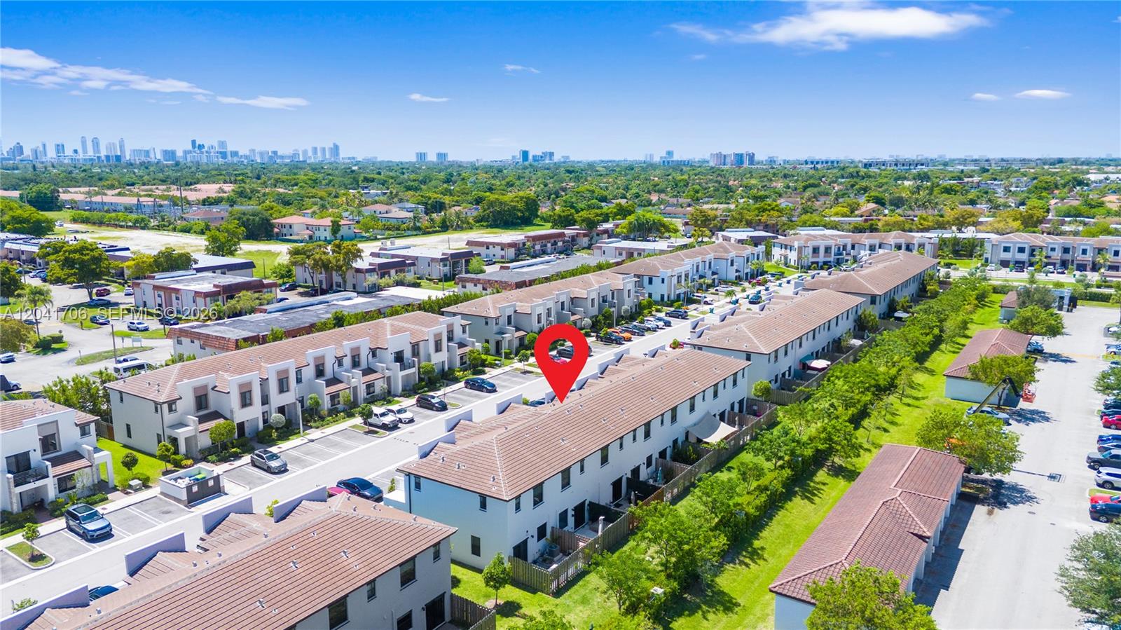 An aerial view shows a row of townhouses with tiled roofs and surrounding parking lots — 21018 NE 8th Ave # 21018, Miami FL 33179, MIAMI, FL