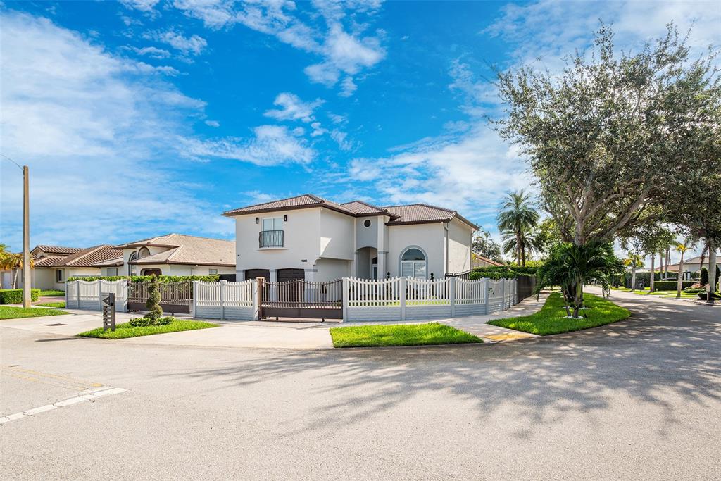 A two-story house with a white exterior, tiled roof, and a fenced-in front yard — 1385 SW 143RD COURT, MIAMI, FL
