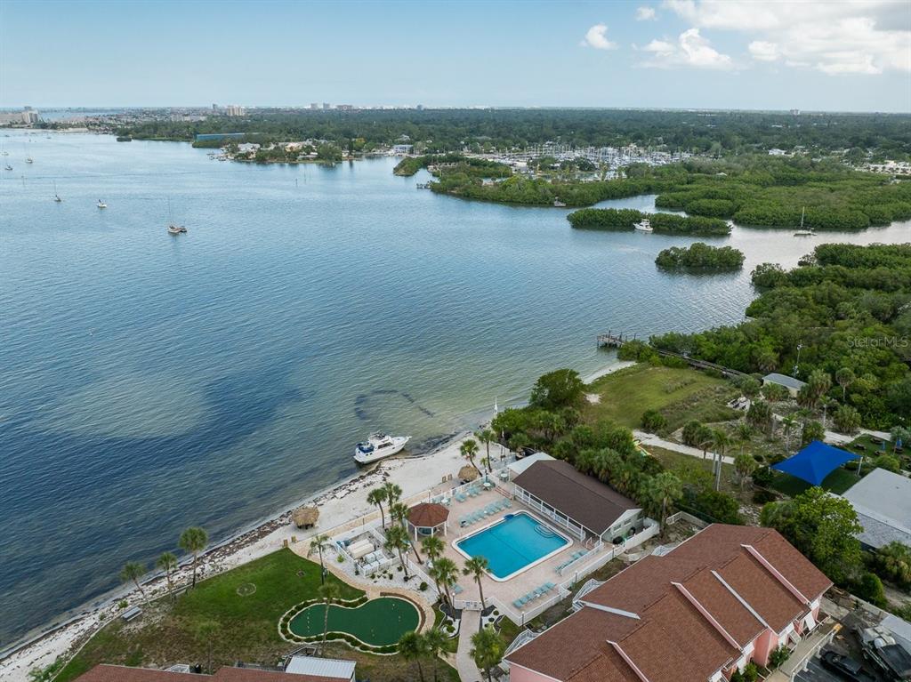 An aerial view of a waterfront property featuring a swimming pool, putting green, and beach — 3640 41ST LANE S UNIT 72E, ST PETERSBURG, FL