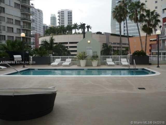 A rectangular swimming pool is surrounded by lounge chairs on a rooftop terrace — 1402 Brickell Bay Dr # 1103, Miami FL 33131, MIAMI, FL