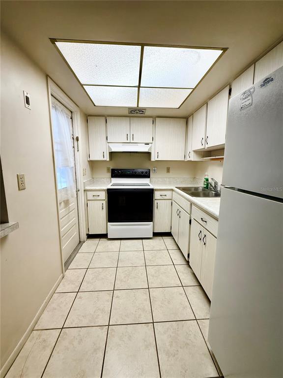 A white single-story duplex features a carport, a front lawn, and a green hedge — 5994 HIBISCUS DRIVE, BRADENTON, FL