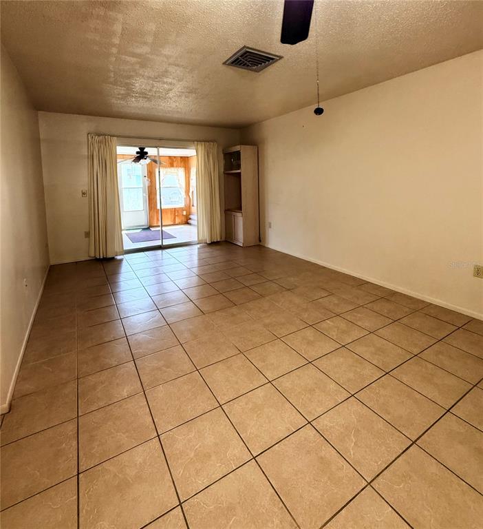 A covered carport area features white vertical siding, a concrete floor, and two entry doors — 5994 HIBISCUS DRIVE, BRADENTON, FL