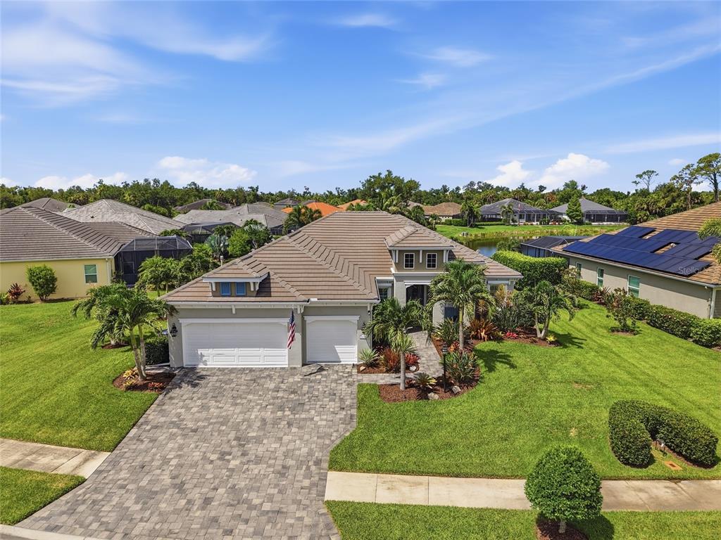 An aerial view of a single-story suburban house with a paver driveway and tile roof — 21253 CHATTAHOOCHEE AVENUE, VENICE, FL
