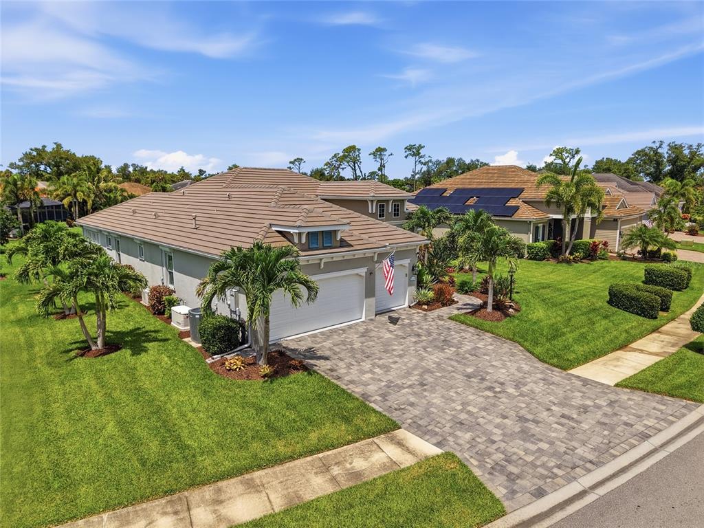 An aerial view shows a single-story house with a tiled roof, paver driveway, and landscaping — 21253 CHATTAHOOCHEE AVENUE, VENICE, FL