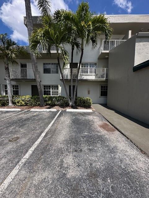 An exterior view of a multi-story apartment building with palm trees and a parking lot — 7510 SW 152nd Ave # C201, Miami FL 33193, MIAMI, FL