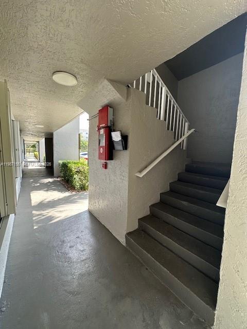 An outdoor concrete staircase leads to an upper level next to a building wall — 7510 SW 152nd Ave # C201, Miami FL 33193, MIAMI, FL