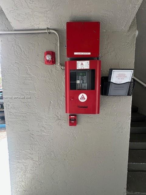A red fire alarm control panel is mounted on a textured, light-colored wall — 7510 SW 152nd Ave # C201, Miami FL 33193, MIAMI, FL