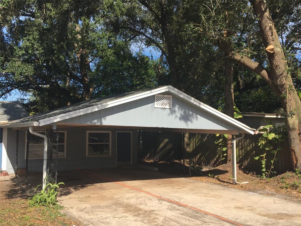 A single-story house with a large attached carport and a concrete driveway under mature trees — 731 23RD STREET UNIT 3, ORLANDO, FL