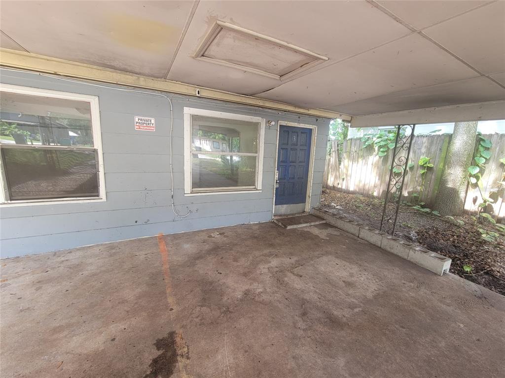 A covered concrete patio features a blue door, two windows, and a private property sign — 731 23RD STREET UNIT 3, ORLANDO, FL